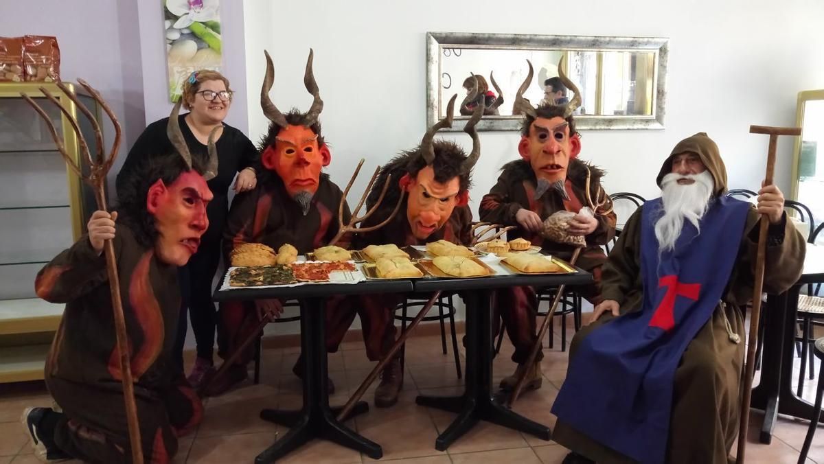 Dimonis i Sant Antoni asseguts a taula