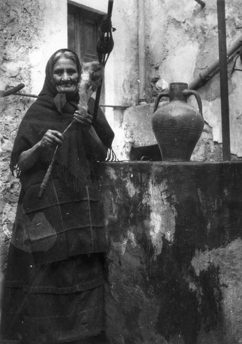 Dona gran filant al costat d'un pou i un càntir