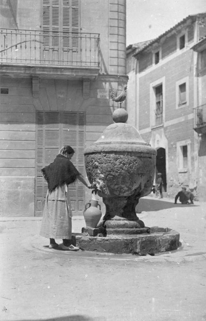 Dona omplint una gerra en una font a Pollença