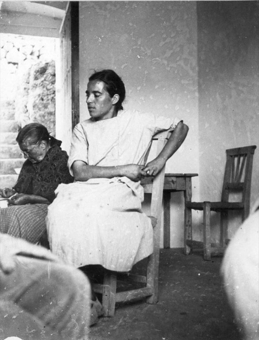 Two women sitting inside a house in the neighborhood of Les Rotes d' Alaró , one cus