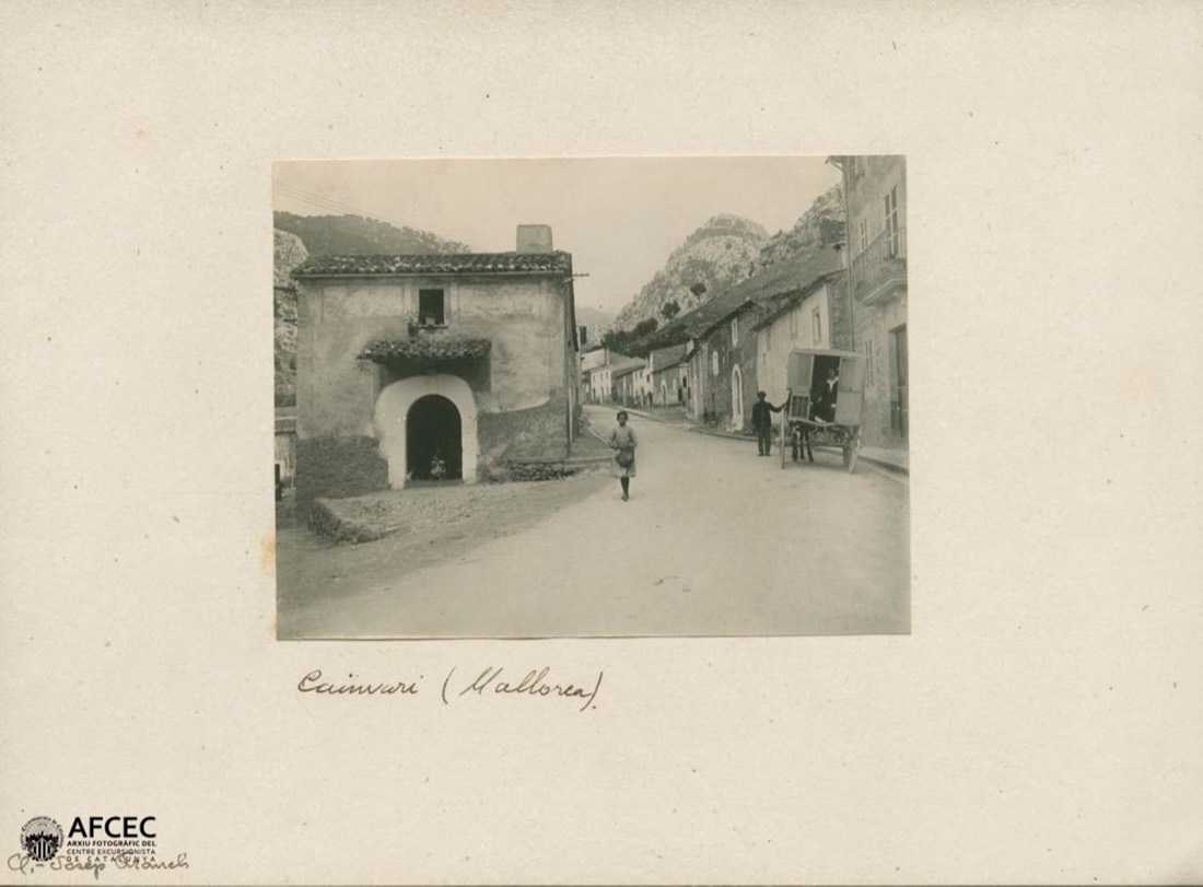 People and cart in a street in the village of Caimari