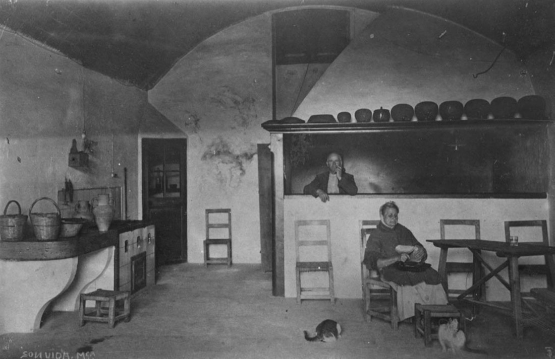Una dona i un home, mobles i estris diversos a la cuina de Son vida